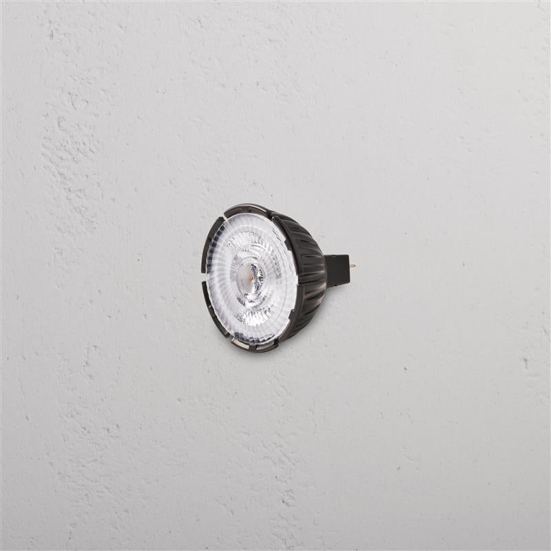 Leopold 7W 50mm 24V LED MR16 24° GU10 bulb with clear lens and black base, shown mounted on a wall.