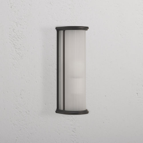 Medium Bank Wall Light Fluted Glass in bronze finish with fluted frosted glass shade, mounted on white wall.